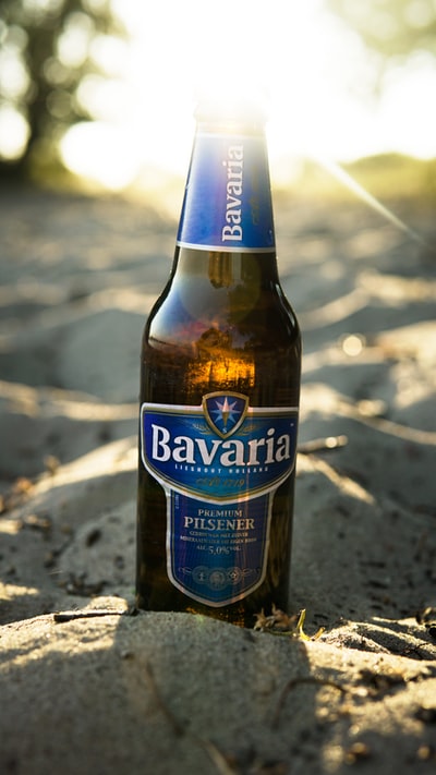 巴伐利亚的比尔森啤酒啤酒瓶子在沙地上

